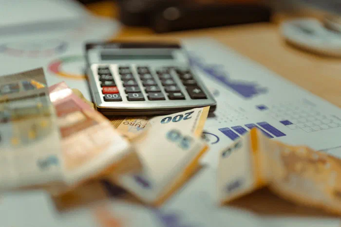 Euro notes and a calculator on top of a financial report