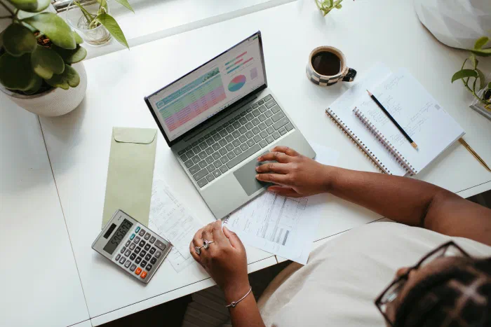 A business owner working through bills and financial reports at a home desk
