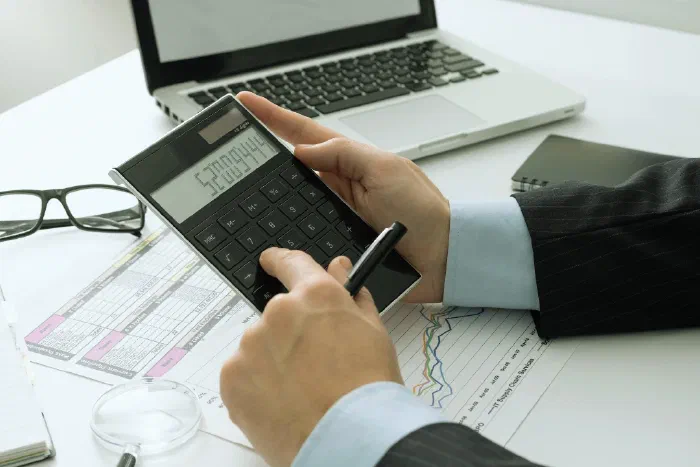 A person reviewing financial reports and compliance documents at a desk