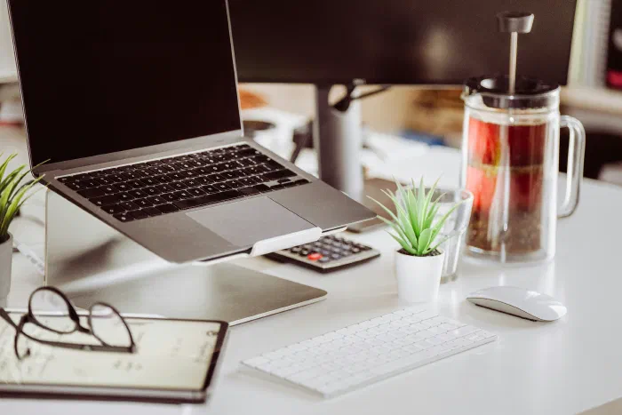 An organised, tidy desk setup with a laptop and calculator