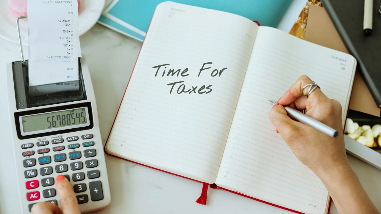 Person writing "Time for Taxes" in a notebook beside a calculator and receipts, representing Form 11 Self-Assessment Ireland.