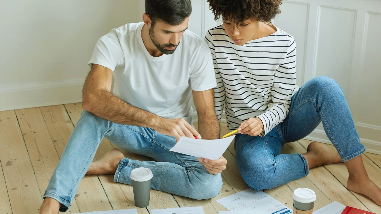 Two people reviewing documents on the floor, representing Business Finance Templates & Checklists Ireland.