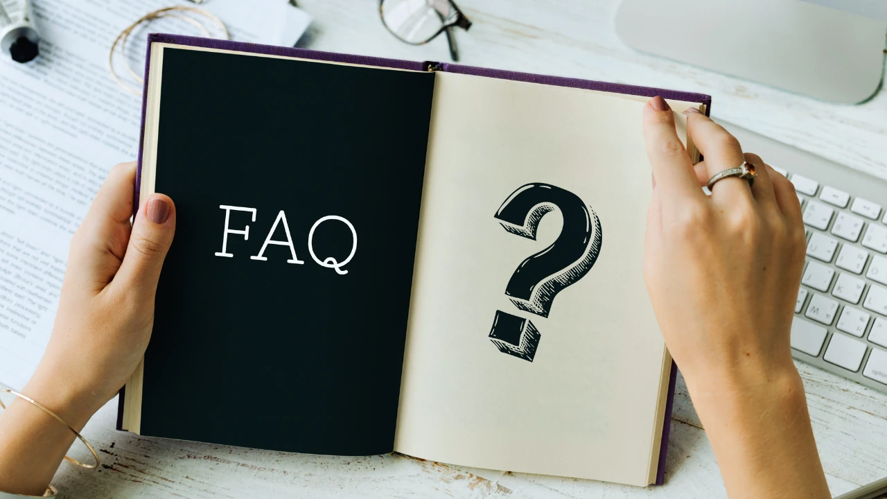 Open book showing the words FAQ and a question mark, representing business finance FAQs in Ireland