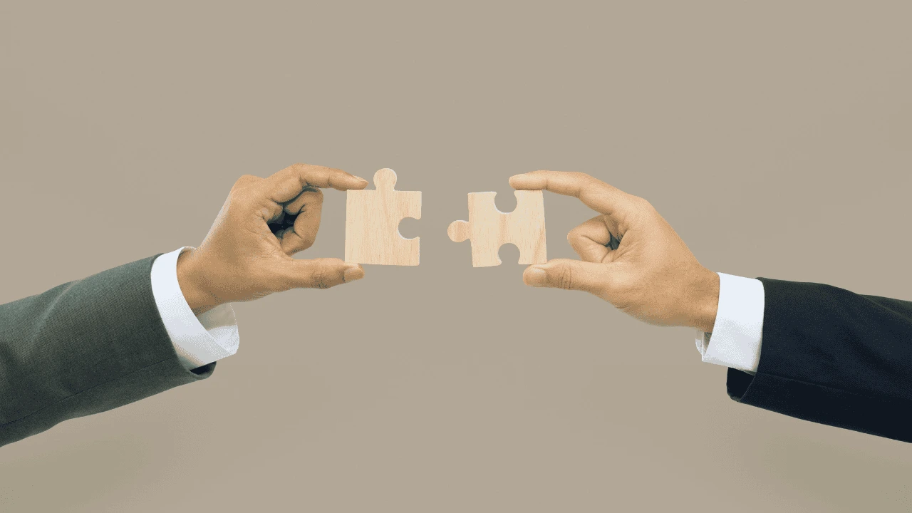 Two business professionals holding puzzle pieces symbolising tailored Small Business Accounting Support in Ireland.
