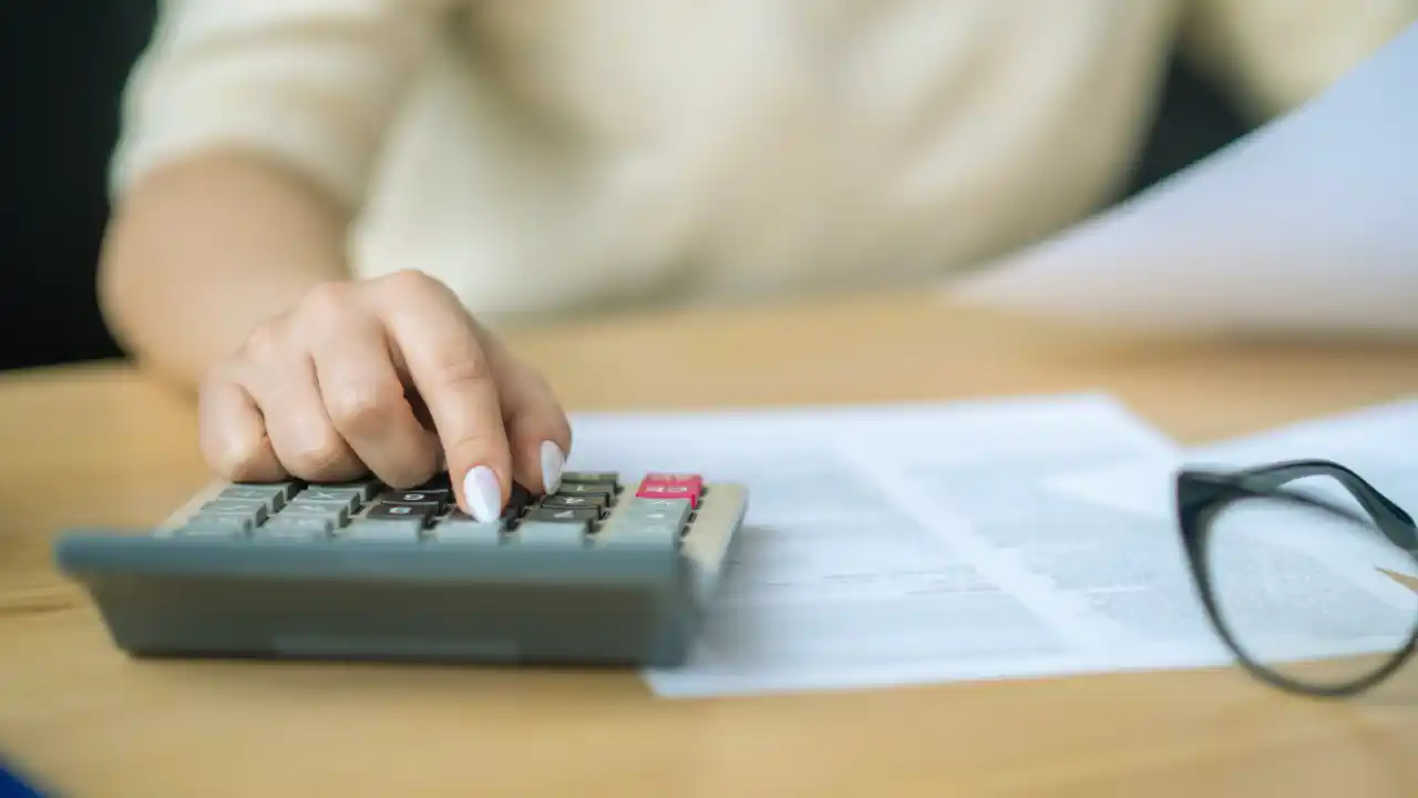 Business owner using calculator and reviewing documents related to Budget 2026 Ireland small business